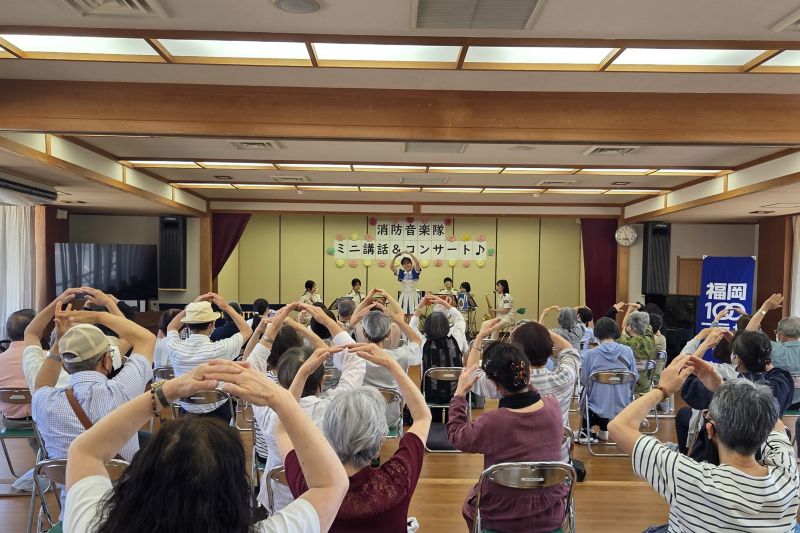 ステージ上で演技をする福岡市消防カラーガード隊の写真