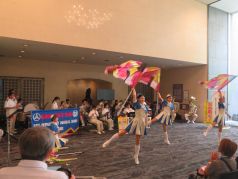 「宝島」でフラッグを振って演技を行う福岡市消防カラーガード隊の写真