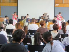 金管打楽器アンサンブルの演奏に合わせてダンスを披露するカラーガード隊の写真