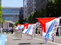 はかた駅前どんたくストリートでフラッグ演技をするカラーガード隊の写真