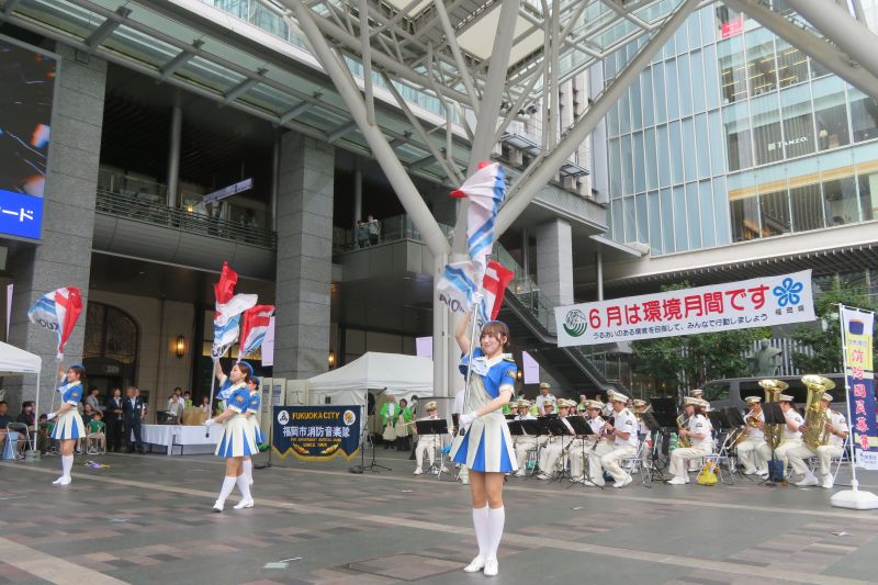 博多口イベントスペースで演奏演技をする福岡市消防音楽隊カラーガード隊の写真