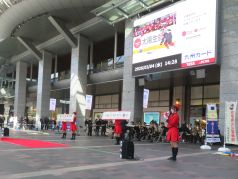 演奏をする消防音楽隊と、クイズを出題するカラーガード隊の写真