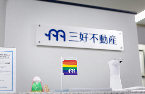 三好不動産の看板とレインボーフラッグの写真