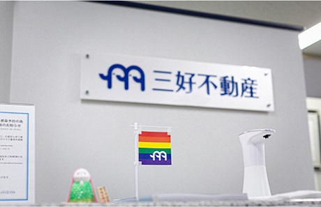 三好不動産の看板とレインボーフラッグの写真