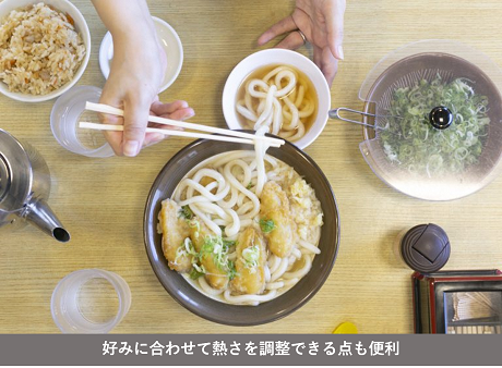 うどんを冷たいスープに入れている様子（好みに合わせて暑さを調整できる点も便利）