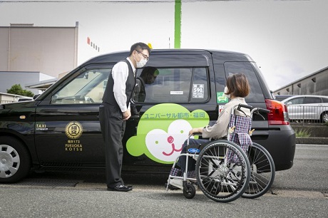 ユニバーサルデザインタクシーと車いすを利用している乗客の写真